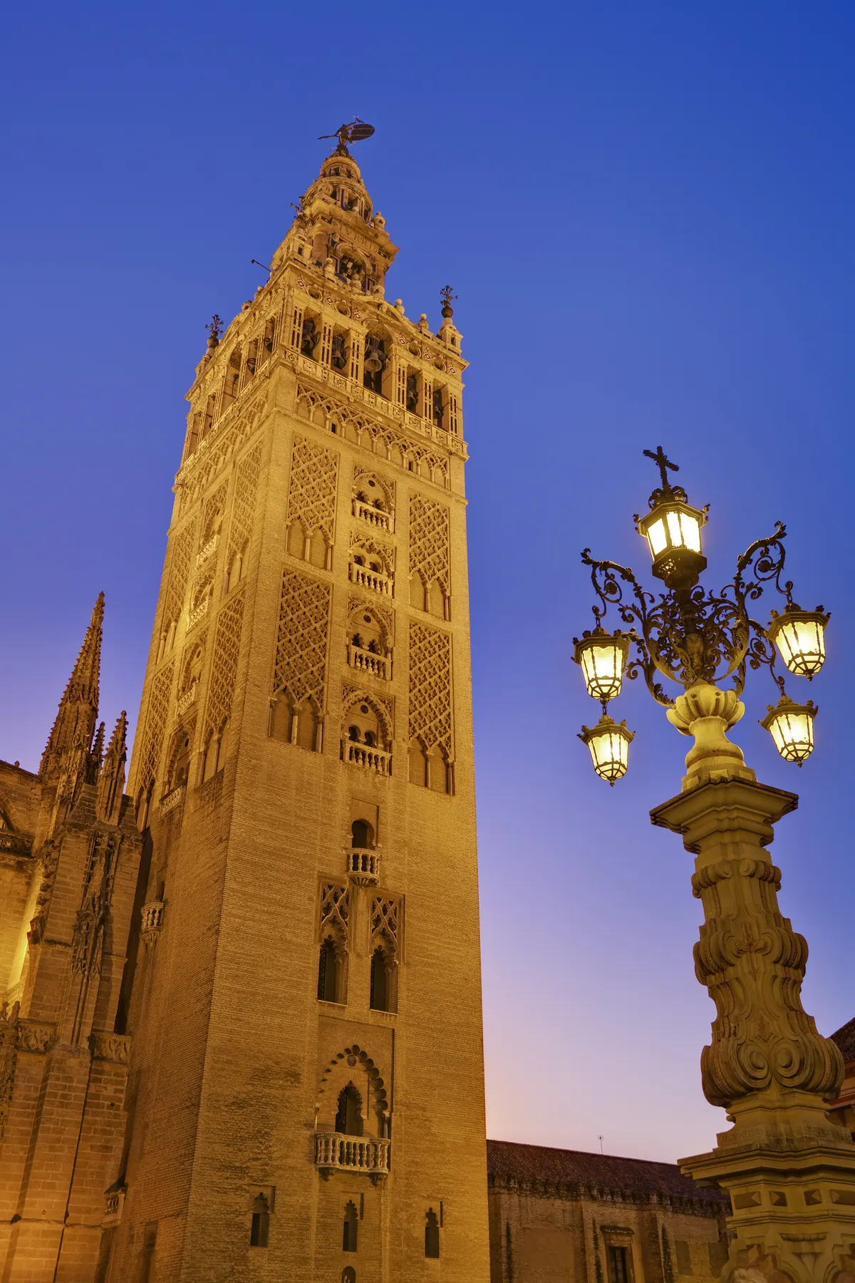 Vista al atardecer de la Giralda, torre-campanario de la Catedral de Sevilla, fotografiada desde la Plaza Virgen de los Reyes
